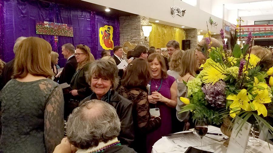 Hallway full of attendees at the 13th Annual Mardi Gras Gala.
