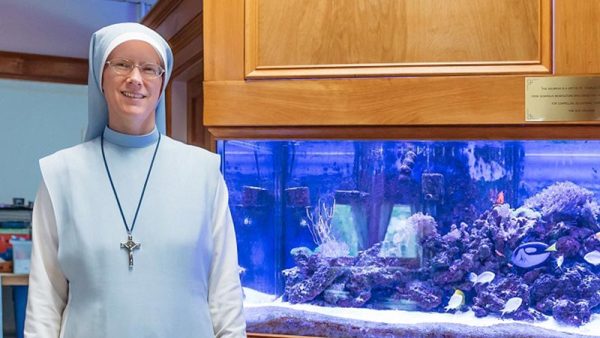 Administrator Sr. Mary Agnes stand next to the aquarium at the St. Charles School in Rochester, NH.