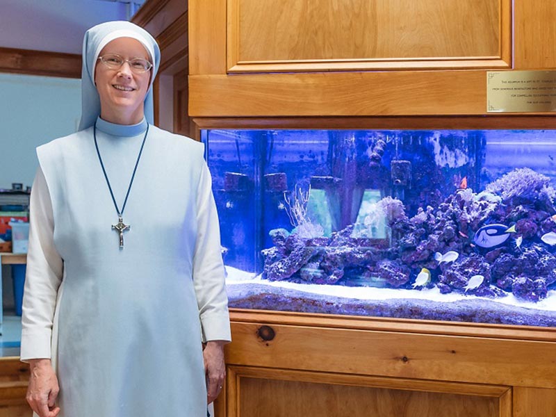 Administrator Sr. Mary Agnes stand next to the aquarium at the St. Charles School in Rochester, NH.