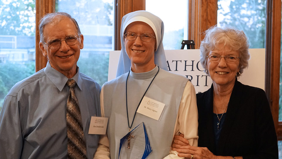 Sr. Mary Agnes Dombroski, recipient of the In His Footsteps Award, flanked by her parents Jim and Jane.