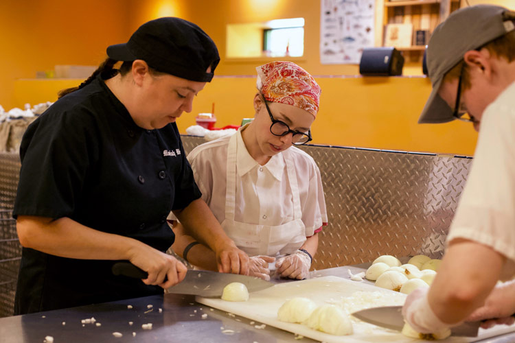 NH Food Bank Recipe for Success Production Assistant Moriah Webster trains students.